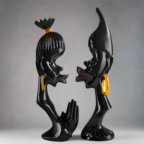 Black and gold sculpture of two figures on a white background