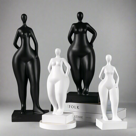 Black and white female figure sculptures on a gray background